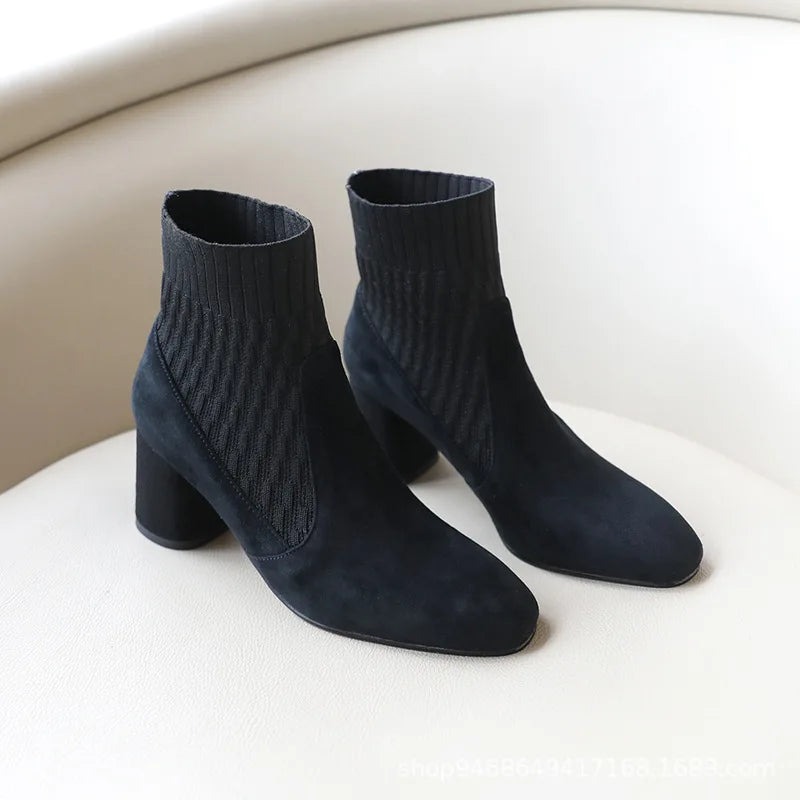  A pair of black casual lightweight ankle heel boots with a thick heel, against a neutral background