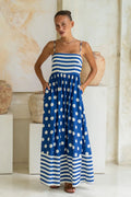 A sleeveless, high-waisted, midi-length dress with a printed pattern and a one-shoulder, backless design, photographed on a white background.