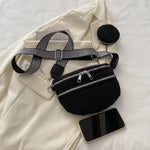 A medium-sized black crossbody bag made of PU material, adorned with metallic studs and featuring an adjustable strap.
