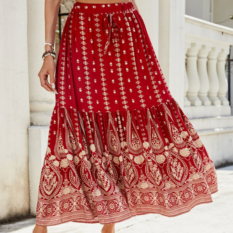 A woman wearing a vibrant, red, flared hem midi skirt with a high waist and pleated details.