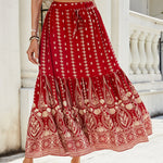 A woman wearing a vibrant, red, flared hem midi skirt with a high waist and pleated details.