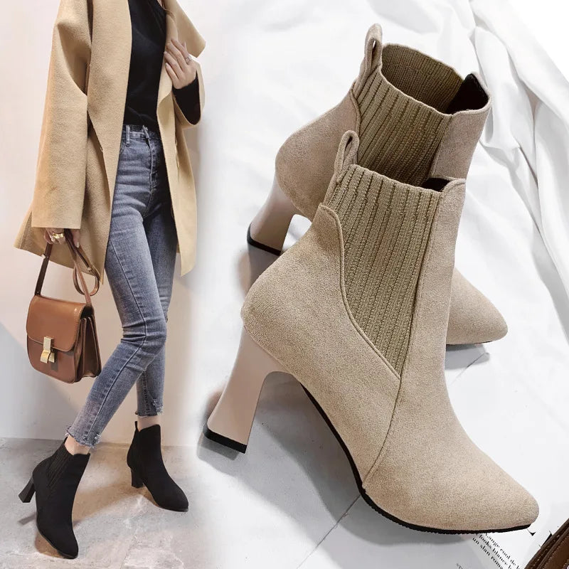 A pair of black high heel platform Martin boots with a pointed toe and thick heel.