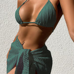 Person wearing a green bikini with a matching sarong against a light background